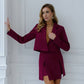 A burgundy suit with a crop jacket and skirt-shorts