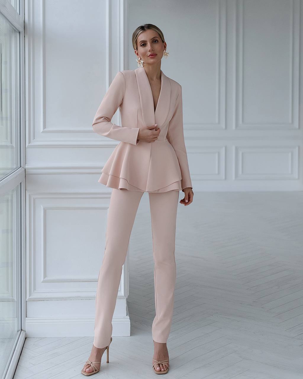 A beige suit with a peplum jacket and tapered trousers