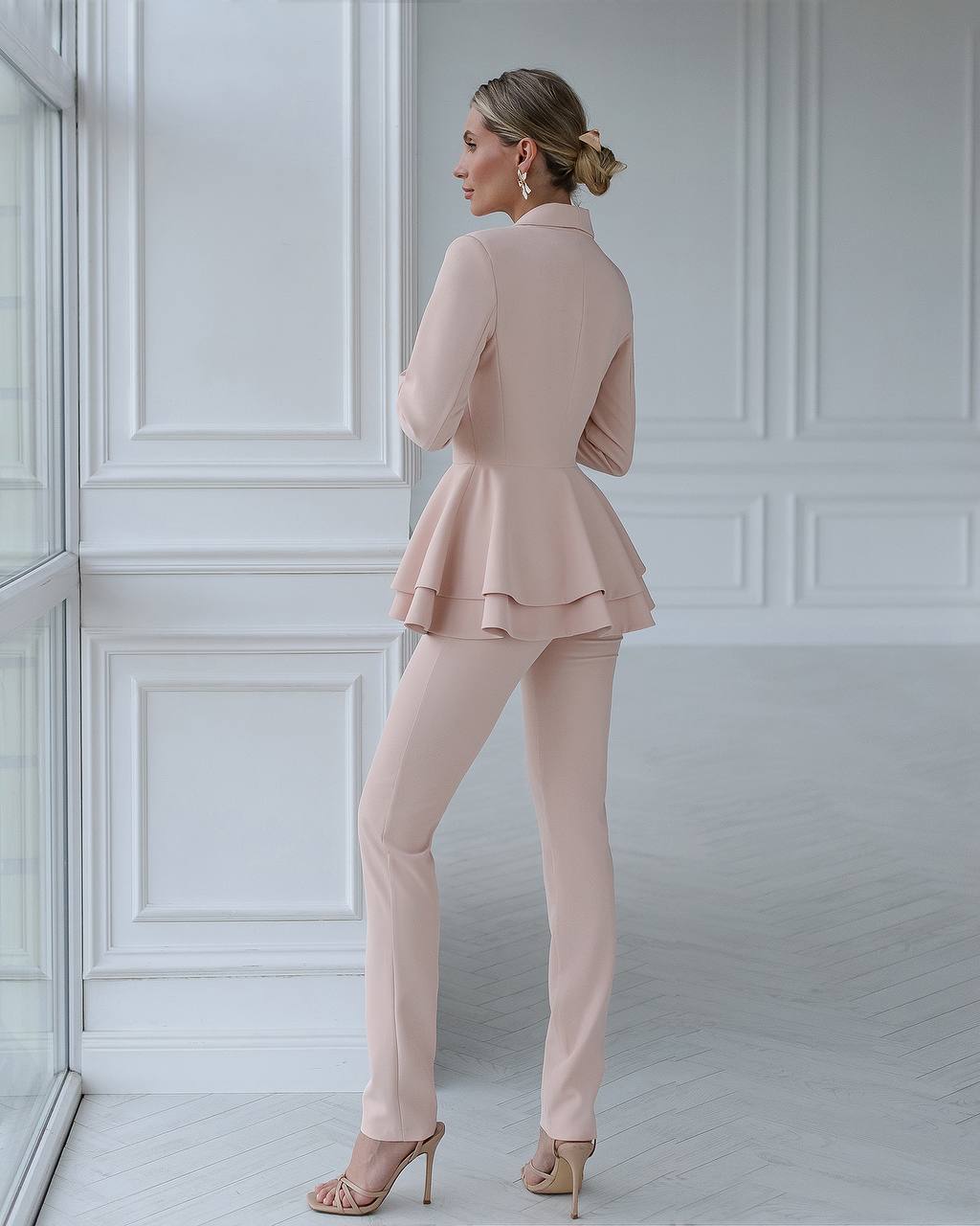 A beige suit with a peplum jacket and tapered trousers