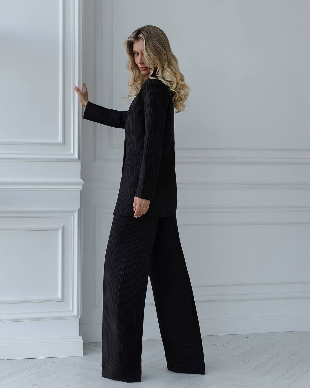 A black suit with a straight jacket and wide trousers