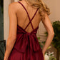 Burgundy dress with an open back and a lush skirt